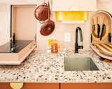 Two pull-down compartments in the kitchen hide an electric cooktop and chopping block, while paper towels are tucked away in a curved yellow container. “I didn’t want anything out in the open,” Ash says.