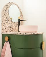The bathroom vanity, with a countertop made of Pacifica millennial pink retro mix terrazzo from Concrete Collaborative, was one of the most complex parts of the project. “Curved forms are a lot of work,” Ash says. The designer’s inspiration for the curved motif and color palette came from an antique stained glass window.