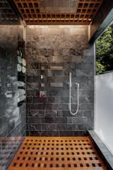 The stone-tiled rain shower offers beautiful views to the backyard and convenient shelving for towels and bath products.