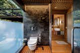 "The two main-level baths were modernized this year and both include subway tile and Ann Sacks tile floors. The lower bath creates an experience reminiscent of a Kyoto spa with full Dornbracht rain shower, a Duravit heated bidet toilet, a floor-to-ceiling partially frosted window with views to the woods, custom-gridded teak floor and ceiling panels, a custom cedar vanity with a magnifying mirror and built-in towel &amp; soap storage, an antler towel rack, and wi-fi speakers," states the listing.