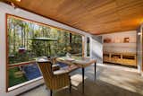 A study with a wall-length floor-to-ceiling panoramic window provides a view of the lush backyard.