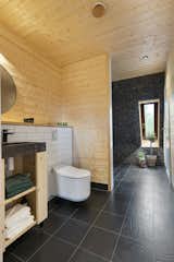 In the master bathroom, the light wood used throughout the house is contrasted with dark tile and stone.