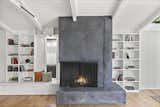 A large cement fireplace serves as a partition between the living and dining areas.