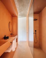 The principal bathroom is bathed with natural light and a warm, burnt-orange palette.