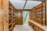 A library space is lined with floor-to-ceiling shelves made from the same cedar used throughout the house.
