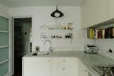 The open kitchen features a Carrara marble countertop and pale pistachio cabinetry.