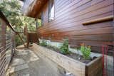 Fenced-in, raised garden beds can be found at the base of the property's lower deck.