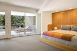 Bright Designlab renovated the primary suite with a bespoke, white oak bed with slatted wall paneling and curving bedside tables, as well as a large en suite bathroom with sauna.&nbsp;