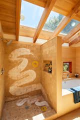 The primary bath features a Kaldewei bathtub and custom shower artwork by Sara Bright.