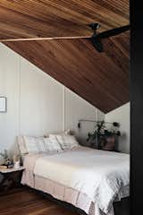 Creating an optical illusion, the ceiling upstairs in the primary bedroom breaks at a severe angle to meet the corner of the home.