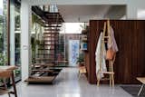 Inside, a floating staircase of steel and lapacho wood helps maintain the home’s openness. The benches, bookshelves, and A-frame coatrack are by Teresa and Nico’s design firm, La Base Studio.  Photo 4 of 14 in In Buenos Aires, a Family’s Experimental Renovation Tests the Boundaries of a Busy Street Corner
