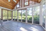 A glass-enclosed sunroom offers an idyllic spot to savor the landscape all year round.&nbsp;