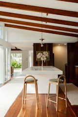 In the kitchen a large, polished onyx island pops against the surrounding wooden cabinetry.