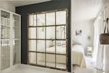 A partition crafted from a reclaimed window allows ample light to sweep into the bedroom.