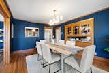 Original details can be found throughout, including refinished hardwood floors and built-in cabinetry. The thick wood trim lining the dining and living areas pops against the blue walls.