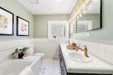 Lined with tile, the primary bathroom features a large soaking tub, as well as a dual vanity.