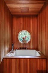 A cedar-clad soaking tub awaits in the primary en suite bath located on the upper level.