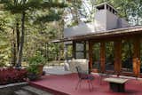 A large deck overlooking the forested backyard further extends the gathering spaces.