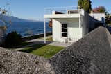 Villa "Le Lac" in Corseaux, Switzerland, was designed by Le Corbusier for his parents in 1923. This view, photographed by Jürg Gasser, shows the northeast facade, where a wall runs the perimeter of the property.