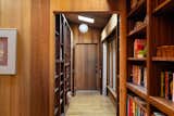 Floor-to-ceiling built-in shelving lines the hallway leading to one of the four bedrooms.