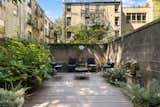 Surrounded by concrete walls, the lush garden in the back is a private city oasis.