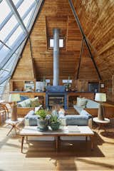 The upper level frames picturesque views of the Fire Island National Seashore. An original blue-tiled fireplace serves as a subtle partition between the living room and kitchen.&nbsp;