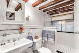 Beams continue into the en suite bathroom, which is clad in white subway tiles.