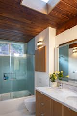 Blue tile adds a splash of color to the top-floor bathroom, complete with a large skylight.