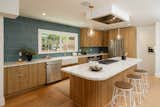 The revamped kitchen features wooden cabinetry and a colorful backsplash.&nbsp;