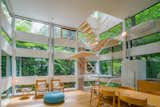 Inside, an open, wooden staircase connects the main living areas located on the lower level with the two bedrooms and baths perched above.