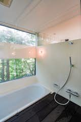 One of the home’s bathrooms features a large soaking tub overlooking the natural setting.