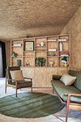 Martin designed and built the partition between the bedroom and living area (a bookcase on one side and a wardrobe on the other) to allow air and light to flow through the 474-square-foot space. The living area has a rug from Pampa and vintage Narvik seating designed by Fler and restored by Martin.