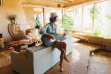 Steve’s wife, Jess Ludwicki, who helped with the interior design, plays guitar in the living area. "Probably Fleetwood Mac," says Trent. "RIP Christine McVie." The walls in the earthship are adobe, and the floors are poured concrete with a linseed oil finish.