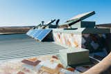 The metal scales on the roof are made from recycled scraps of old washers, dryers, and car siding. Reynolds chose the design for a number of his builds, says Trent. “It leaks a bit, so we’ve had to do some maintenance,” he adds, “but it’s no big deal.” Six solar panels feed into a battery box behind them.