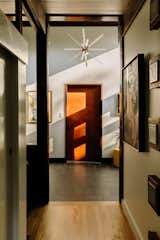 A Photon chandelier by Tech Lighting hangs in the entryway, surrounded by John and Erik’s contemporary art collection.  Photo 2 of 13 in An Artful Restoration Returns a Louisville Home to Its Midcentury Roots