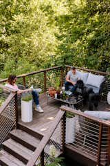 A coumarou deck at the back of the house provides John, Erik, and their dog, Ludwig, with a tranquil place to unwind. “We get an immense amount of enjoyment out of it,” Erik says.  Photo 9 of 13 in An Artful Restoration Returns a Louisville Home to Its Midcentury Roots