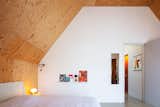 The bedroom ceilings are lined in wisa spruce. “We chose it because we like its grain and could leave it unfinished,” says Farah. “We wanted a calm and natural feeling, but not all wood, so we combined the wood with clean concrete flooring and white stucco walls.”  Photo 7 of 13 in An Architect Couple Trade Size for Sustainability in Their Family’s Amsterdam Home