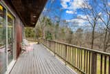 A closer look at the partially covered deck overlooking the lush, wooded lot.