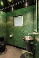 Steps from the primary suite is a power room wrapped in moody, malachite-green wallpaper.