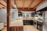 The main level features exposed joists and wide-plank oak floors.