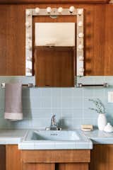 One of the home’s two bathrooms features vintage tile and Hollywood vanity lighting.
