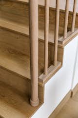 Detail of light wood balusters and tread of staircase. 