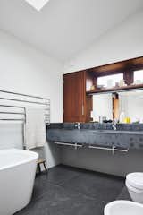 The bathroom in between the three bedrooms on the lower level features a large skylight, double vanity, and freestanding tub.&nbsp;
