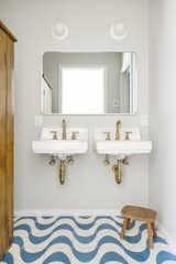 Designer Emily Rand mixed expensive and more affordable finishes to stay within budget, combining Moroccan encaustic Clé tile with wall-mounted sinks from Kohler in the kids’ bathroom.