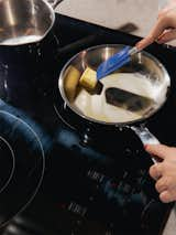 Woman melts butter in pan on induction range