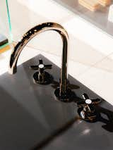 Detail of kitchen faucet with a dark brass finish. 