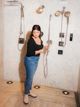 Woman tests out shower head in showroom.