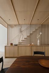 A new cantilevered stair behind a batten screen was key to a more open, light-filled interior—and it offered a consistent design element that cut through the section of the home. “The wood elements really envelope you and define the space,” says architect Ian Starling.  Photo 1 of 10 in A Brooklyn Townhouse Is Seamlessly Transformed With European Oak