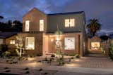 Fitted with numerous windows, both properties beam as modern light-boxes at night.