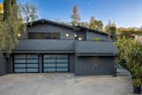 Sporting a handsome gray facade, the shingled home is perched on a private lot, bordered with lush vegetation. A large balcony awaits on the upper level, above the three-car garage.&nbsp;